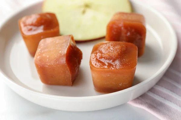 Frozen apple puree cubes with ingredient on table, closeup