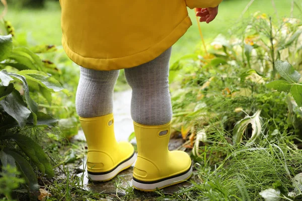 小さな女の子は屋外の水たまりの中に立ってゴム製のブーツを着て クローズアップ バックビュー — ストック写真