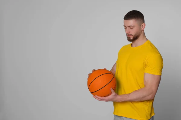 Açık Gri Arka Planda Basketbol Topu Olan Atletik Genç Bir — Stok fotoğraf