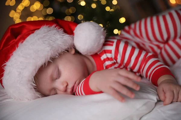 Dziecko Piżamie Bożego Narodzenia Santa Kapelusz Śpi Łóżku Wewnątrz — Zdjęcie stockowe
