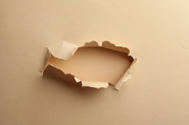 Renk arkaplanı üzerine açık bej kağıtta delik