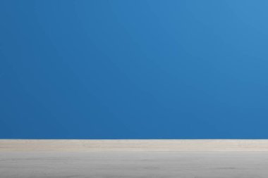 Güzel mavi duvar ve temiz boş odada ahşap zemin.