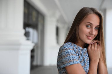 Şık tişörtlü güzel bir kadın. Kapalı mekanda, mesaj için yer var.