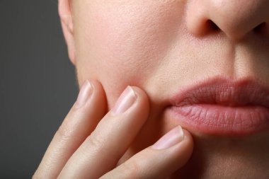 Gri arka planda sağlıklı cilde sahip kadının yakın görüntüsü