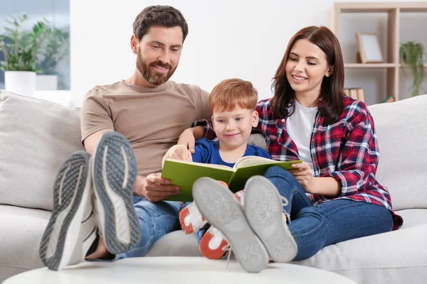 Šťastní Rodiče Svým Dítětem Čtení Knihy Gauči Doma — Stock fotografie