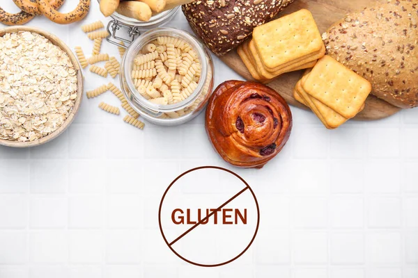Different gluten free products on white tiled table, flat lay