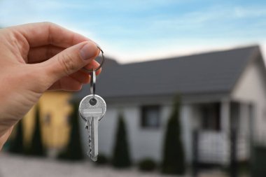 Yeni evin anahtarlarını elinde tutan emlakçı, yakın plan. Metin için boşluk