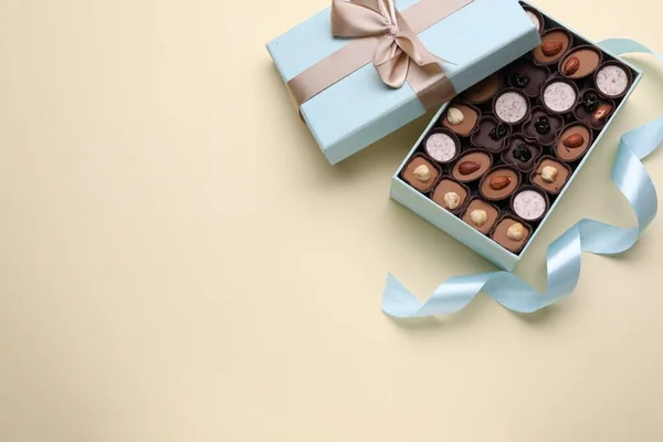 Otevřená Krabice Lahodných Čokoládových Bonbónů Světle Modrá Stuha Béžovém Pozadí — Stock fotografie