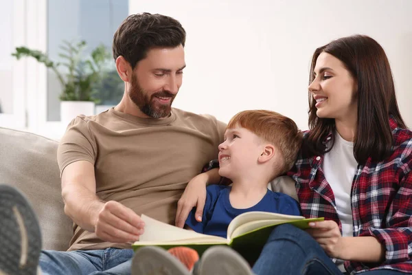 Pais Felizes Com Seu Filho Lendo Livro Sofá Casa — Fotografia de Stock