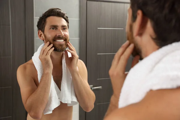 Yakışıklı Sakallı Adam Banyoda Aynaya Bakıyor Ahşap Kapıların Yanında — Stok fotoğraf
