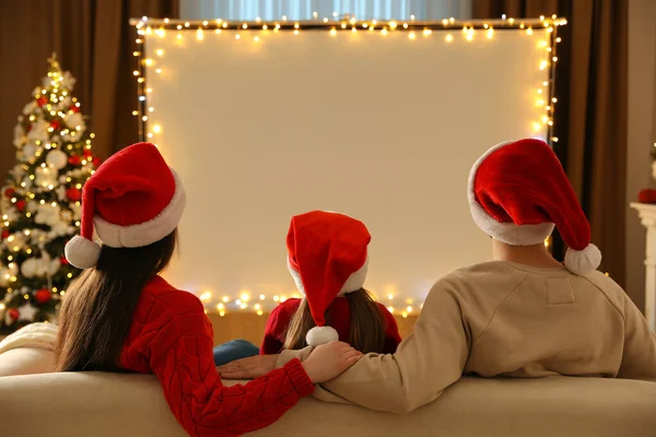 クリスマスのために装飾された部屋の映写スクリーンで家族の監視映画 バックビュー ホームテレビ機器 — ストック写真