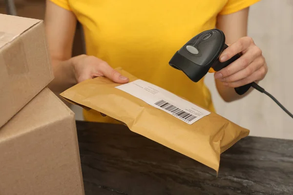 stock image Post office worker with scanner reading parcel barcode at counter indoors, closeup