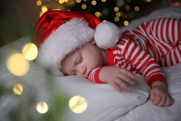 Dziecko Piżamie Bożego Narodzenia Santa Kapelusz Śpi Łóżku Wewnątrz — Zdjęcie stockowe