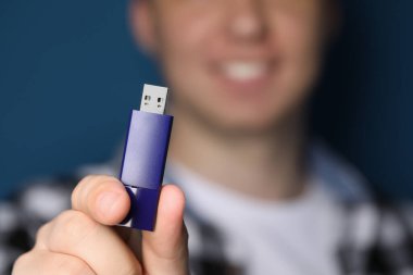 USB bellekli adam mavi arka planda, yakın plan. Metin için boşluk