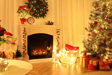 İçinde yanan şömine ve Noel ağacı olan güzel bir oturma odası.