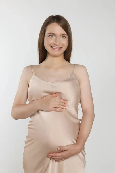 Mujer Embarazada Feliz Tocando Vientre Sobre Fondo Gris Claro —  Fotos de Stock