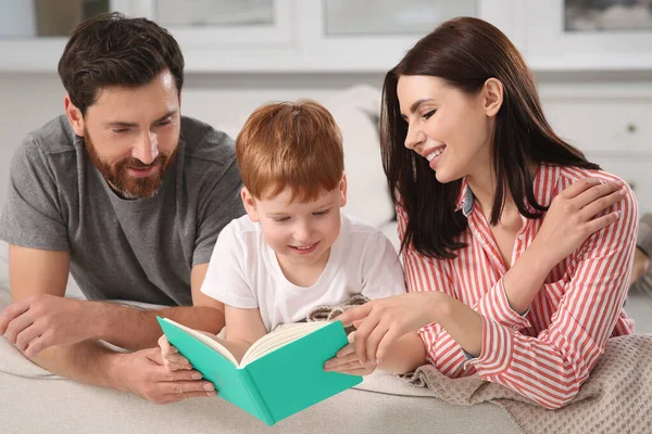 Šťastní Rodiče Svým Dítětem Čtení Knihy Gauči Doma — Stock fotografie