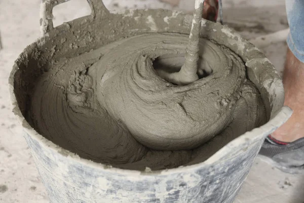 stock image Worker mixing cement in bucket, closeup view