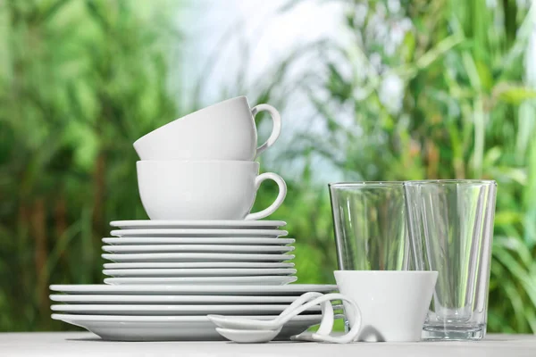 背景がぼやけている白いテーブルの上にきれいな食器のセット — ストック写真