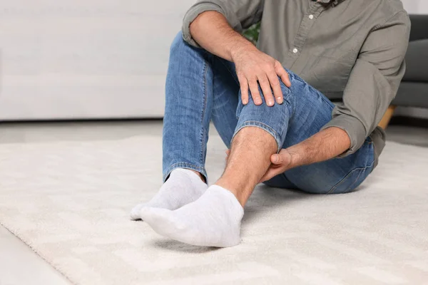 Άντρας Που Υποφέρει Από Πόνο Στα Πόδια Λευκό Χαλί Εσωτερικούς — Φωτογραφία Αρχείου