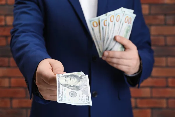 Man Holding Money Red Brick Wall Closeup Currency Exchange — Stock Photo, Image
