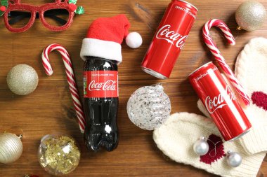 MYKOLAIV, UKRAINE - 01 Ocak 2021: Düz kompozisyon Coca-Cola içecekleri ve ahşap arka planda Noel süslemeleri