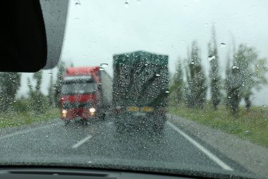 Islak arabanın camından köy yolunu bulanık görüyorum. Yağmurlu hava