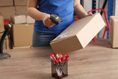 Tarayıcı ile postane çalışanı tezgahta parsel barkodu okuyor, yakın plan