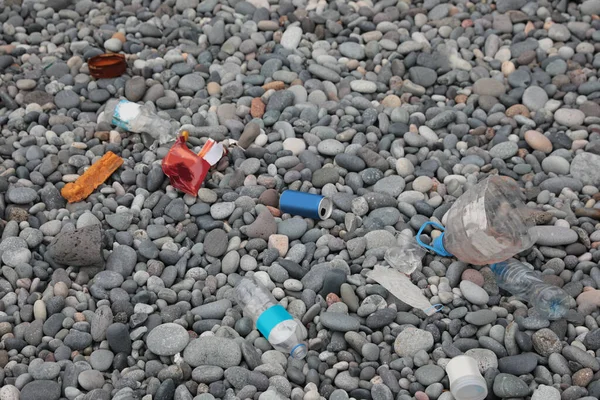 Stock image Garbage scattered on pebbles outdoors. Recycling problem