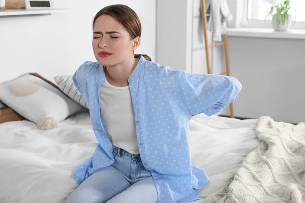 家で寝ている間に腰痛に苦しむ女性 大腸炎の症状 — ストック写真