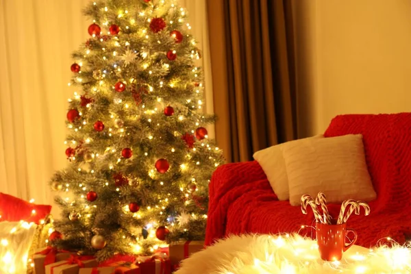 クリスマスのために装飾された部屋のフェイクファーの上にキャンディーの杖を持つ赤いカップ インテリアデザイン — ストック写真