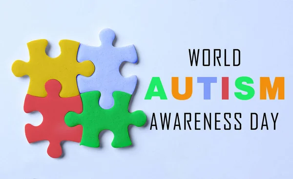Wereld Autisme Bewustmakingsdag Kleurrijke Puzzelstukjes Tekst Lichtblauwe Achtergrond Bovenaanzicht — Stockfoto