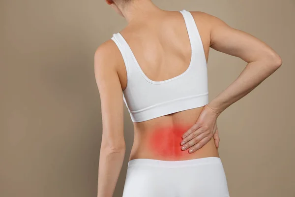Mujer Que Sufre Dolor Espalda Sobre Fondo Beige Primer Plano —  Fotos de Stock
