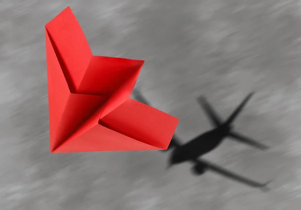 Fliegendes Papierflugzeug Und Schatten Eines Echten Flugzeugs Auf Asphalt — Stockfoto