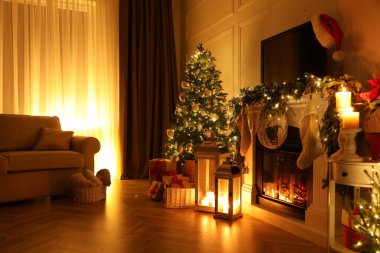 Geceleri şömineli ve Noel dekorlu güzel bir oda.