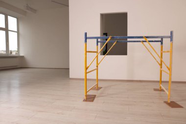 Boş yenilenmiş odada profesyonel yapı iskelesi.