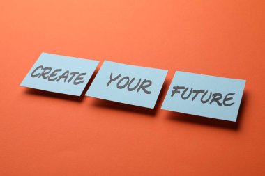 Motivasyon cümlesi Turuncu arkaplandaki kelimelerle yapış yapış notlardan oluşan Geleceğinizi Yaratın