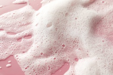 Soluk pembe arka planda beyaz yıkama köpüğü, üst manzara