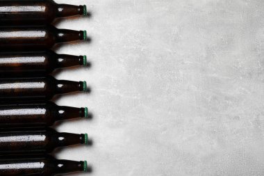 Açık gri zemin üzerinde cam bira şişeleri, düz yatıyordu. Metin için boşluk