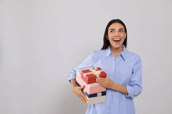 Συναισθηματική Νεαρή Γυναίκα Κρατώντας Κουτιά Δώρων Ανοιχτό Γκρι Φόντο Χώρος — Φωτογραφία Αρχείου