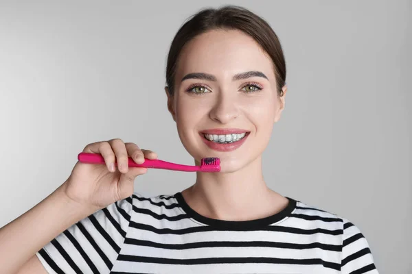 Young Woman Brushing Teeth Charcoal Toothpaste Grey Background — Stock Photo, Image