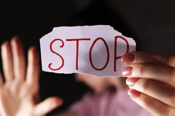 Woman Holding Piece Paper Word Stop Dark Background Closeup Domestic — Stock Photo, Image