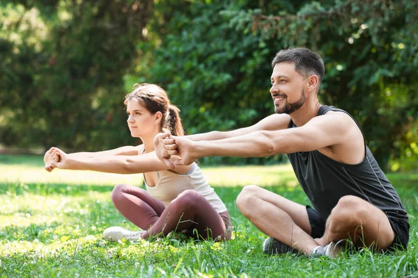 Stock image Man and woman doing morning exercise in park