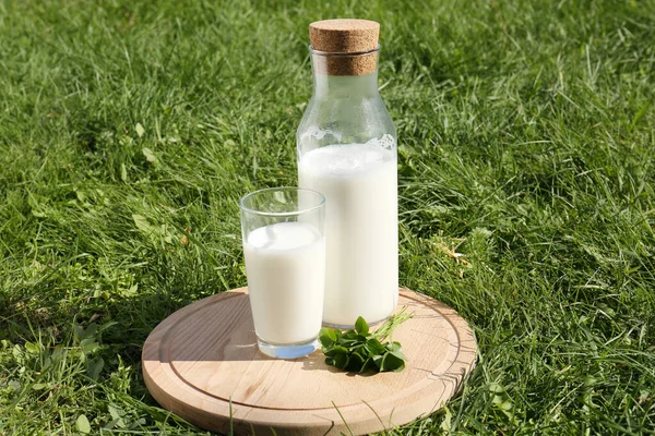 木の板の上のガラスとミルクのボトル屋外 — ストック写真