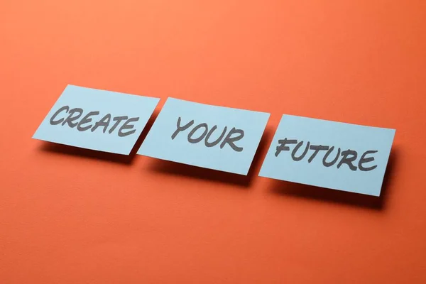 Stock image Motivational phrase Create Your Future made of sticky notes with words on orange background