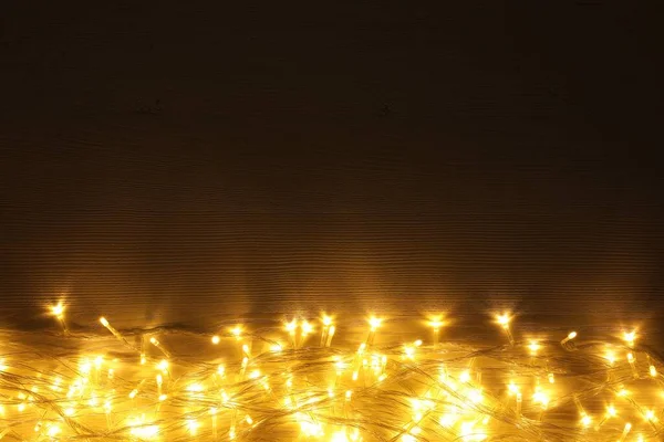 木制桌子上美丽而明亮的圣诞彩灯 尽收眼底 案文的篇幅 — 图库照片