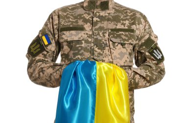 Beyaz arka planda Ukrayna bayrağı olan askeri üniformalı asker, yakın plan.