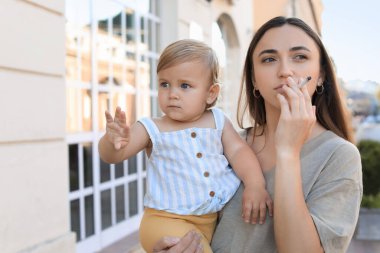 Sigaralı ve çocuklu anne dışarıda. Çocukların yanında sigara içme.