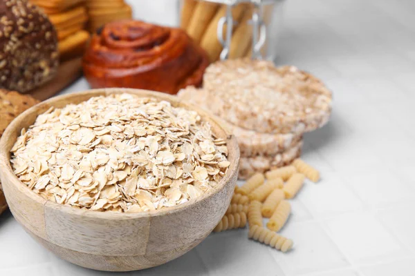 Different gluten free products on white tiled table, closeup