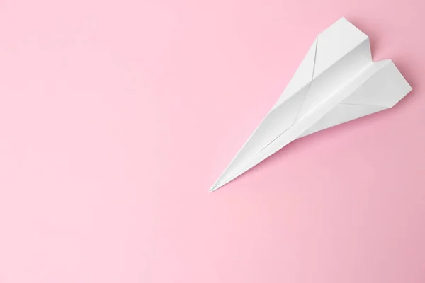 Handmade paper plane on pink background, top view. Space for text